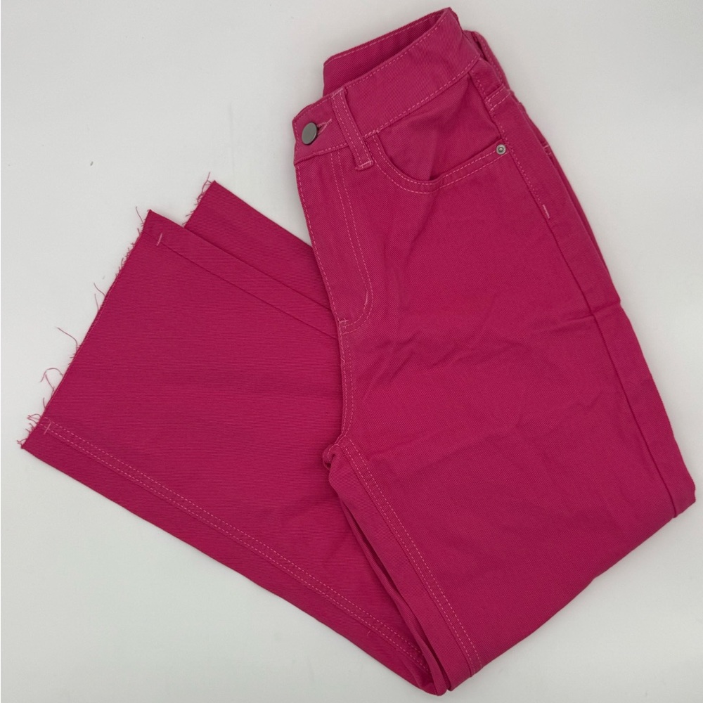 Pink jeans straight legged with raw hem.